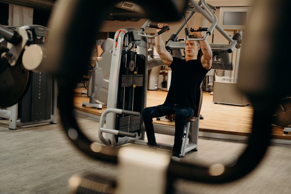 A man working out on a gym machine, focusing on upper body strength training